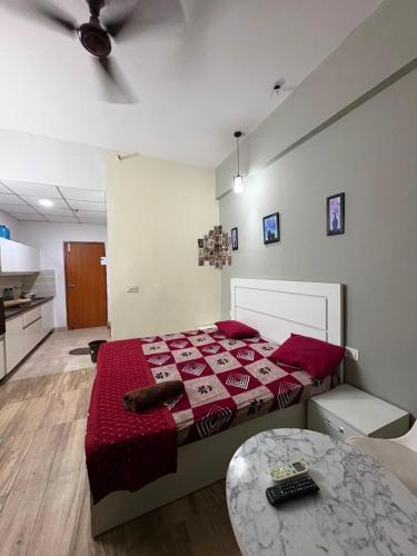 a bedroom with a bed and a table in it at Zen Studio Paramount in Greater Noida