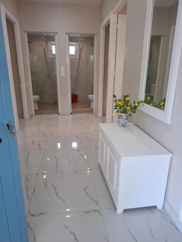 a white marble floor with a vase of flowers on it at Zoya's house in Nea Kallikrateia