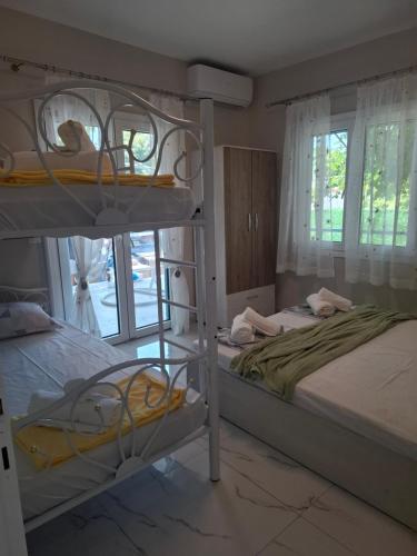 a bedroom with two bunk beds and a window at Zoya's house in Nea Kallikrateia