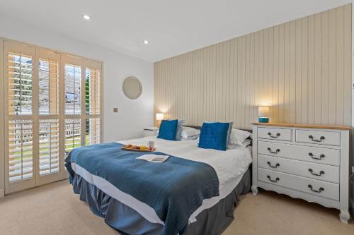 a bedroom with a bed with blue sheets and a dresser at House 34 in Looe