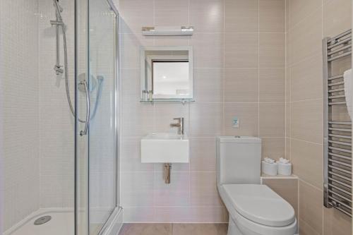 a bathroom with a toilet and a sink and a shower at House 34 in Looe