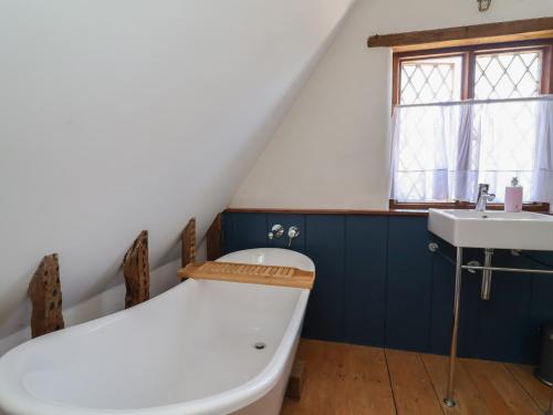 a bathroom with a bath tub and a sink at 1 Fountain Cottages in Tarporley