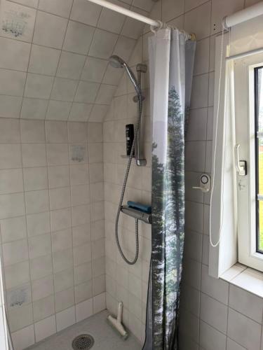 a shower with a shower curtain in a bathroom at Vestergård Gæstehus in Varde