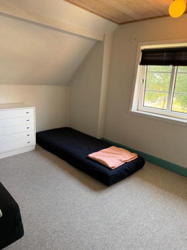 a bedroom with a bed and a window at Vestergård Gæstehus in Varde