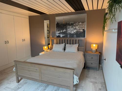 a bedroom with a large bed with two lamps on tables at Huis krekelhof in Antwerp