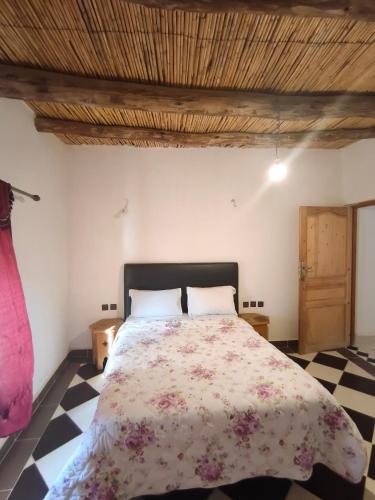 a bedroom with a large bed with a floral bedspread at Hostel amodou in Tinerhir