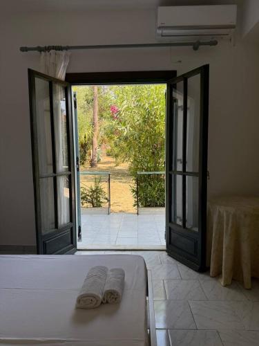 an open door to a room with two towels on a bed at Villa Filoxenia Studios Alykes in Katastárion