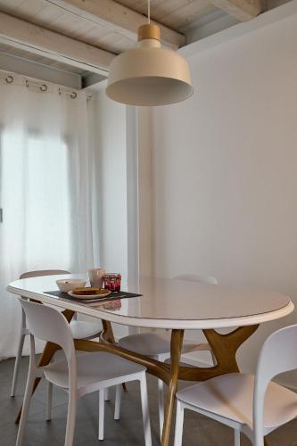 a white dining room with a white table and chairs at Sottomarina Suite Palazzo Storico in Chioggia
