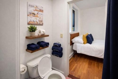 a small bathroom with a toilet and a bed at RENU on Tremont in Boston