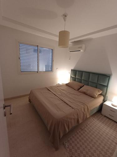 a bedroom with a large bed and two windows at Le charment in Sukrah