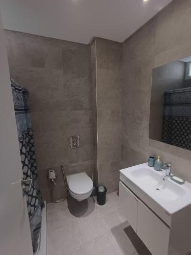 a bathroom with a toilet and a sink at Le charment in Sukrah