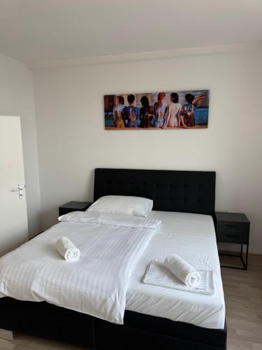 a bedroom with a large white bed with two towels at Central Walk Apartment in Bratislava