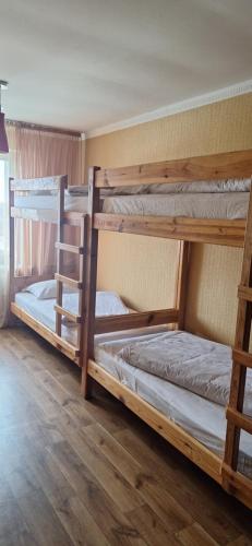 two bunk beds in a room with wooden floors at Poduszka mini-hotel in Stantsiya Rokitno Volynskoye