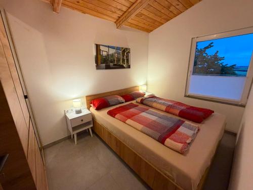 a small bedroom with a bed with a window at Panorama Chalet Fahner Höhe nahe Erfurt mit Klimaanlage in Witterda