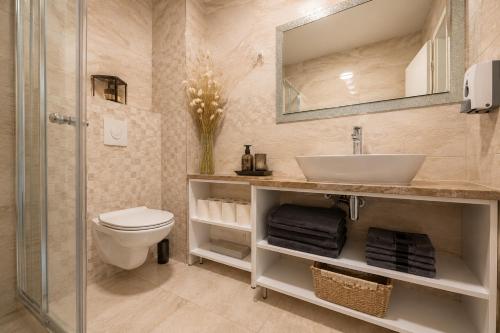a bathroom with a sink and a toilet and a mirror at Johanan in Makarska
