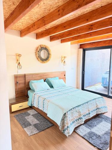 a bedroom with a bed and a large window at Encantos da Aldeia - Casa da Pedra in Oliveira de Azemeis