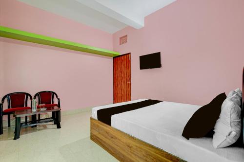 a bedroom with a bed and a table and chairs at Hotel O Muna Heritage Guest House in Cuttack