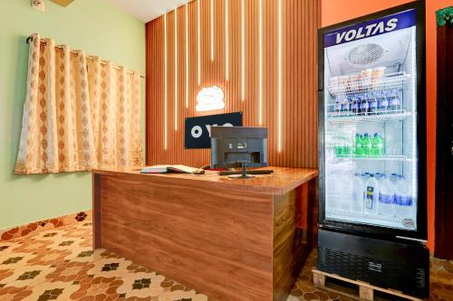 a vending machine with a refrigerator with drinks in it at Hotel O Muna Heritage Guest House in Cuttack