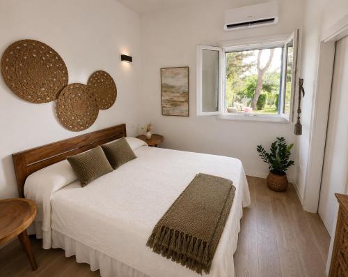 a bedroom with a white bed and a window at I Trulli di Federico in Selva di Fasano