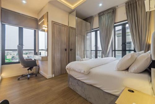 a hotel room with a bed and a desk and windows at Zuma Tan in Lagos