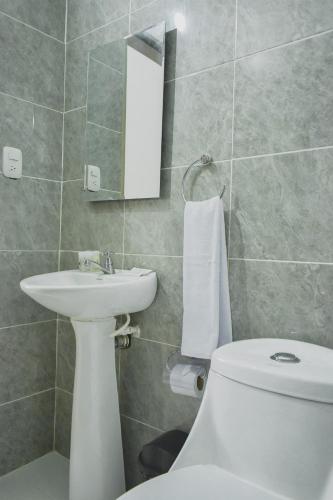 a bathroom with a toilet and a sink and a mirror at Hotel El Marqués De Manga in Cartagena de Indias