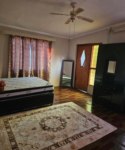 a bedroom with a bed and a ceiling fan at JJK free Breakfast in Barberton