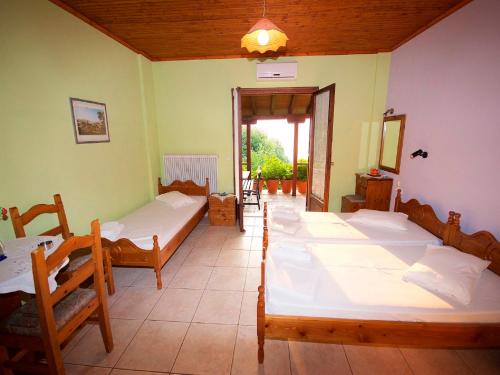 Cette chambre comprend 4 lits et une fenêtre. dans l'établissement Villa Aglaini, à Ágios Dimítrios