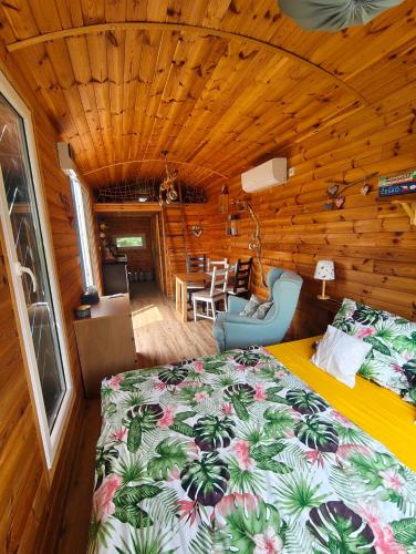 a bedroom with a bed in a log cabin at Slovácká maringotka in Šumice