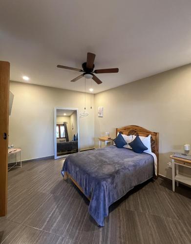 a bedroom with a bed with a ceiling fan at Sierra Norte By Chic Hotel Group in Tepoztlán