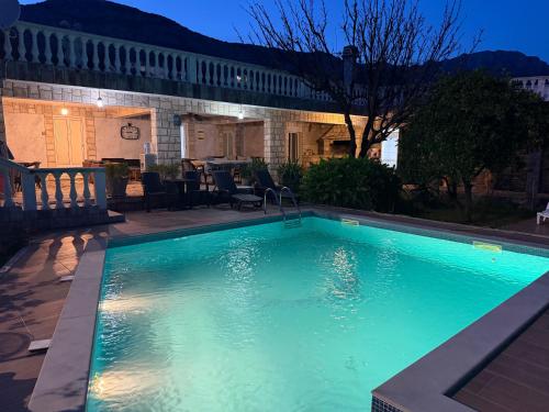 a swimming pool with blue water in front of a house at Andolly Apartments in Bar
