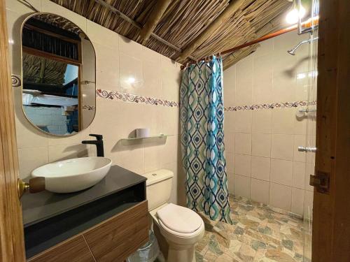 a bathroom with a sink and a toilet and a mirror at Bikini Hotel & Pool in Palomino