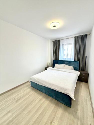 a bedroom with a bed and a wooden floor at Blue Apartment with Free Parking&Self Check-in in Bistriţa