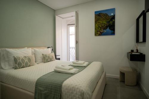 a bedroom with a bed with two towels on it at Côa River Apartment in Vila Nova de Foz Coa