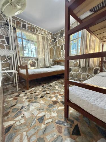 a bedroom with two bunk beds and a stone wall at Cabañas El Itali in Fusagasuga