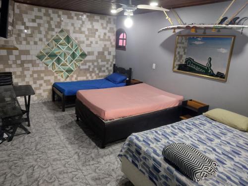 a room with two beds and a table in it at Recanto dos Loureiros in Saquarema