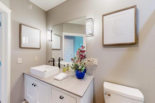 a bathroom with a sink and a toilet and a mirror at Bentonvilla in Bentonville