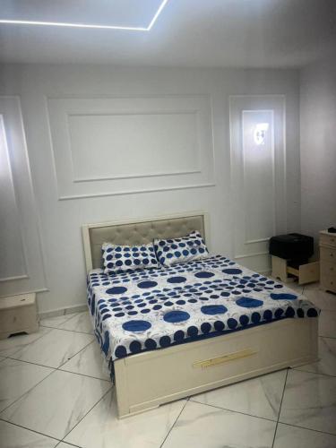 a bedroom with a bed with blue and white sheets at Oran Choupot boulevard principale in Oran