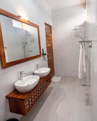 a bathroom with two sinks and a mirror at Isla Bonita Zanzibar Beach Resort in Matemwe