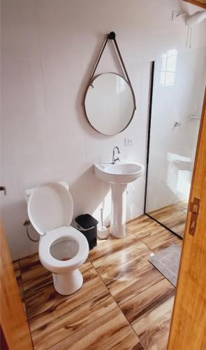 a bathroom with a toilet and a sink at Chalé do Campo in Palmeira