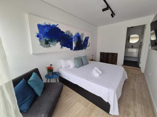 a bedroom with a large white bed and a couch at Suite atlántica in Oya