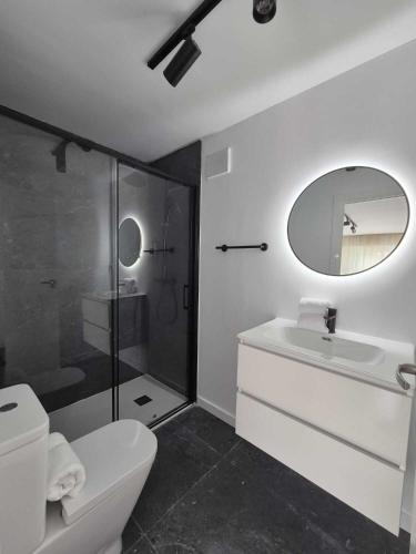 a bathroom with a toilet and a sink and a mirror at Suite atlántica in Oya