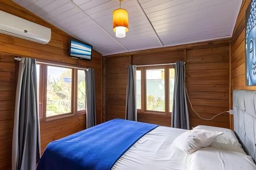 a bedroom with a bed in a room with wooden walls at Chalés da Guarda do Embaú in Guarda do Embaú