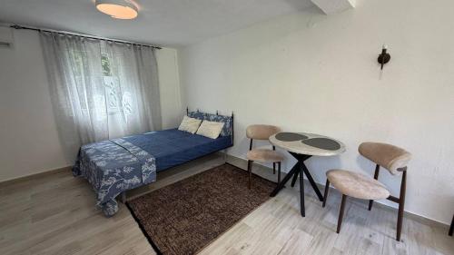 a bedroom with a bed and a table and chairs at Lime by Kotor in Muo