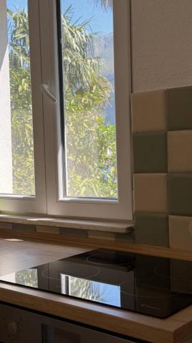 a kitchen with two windows and a microwave at Lime by Kotor in Muo