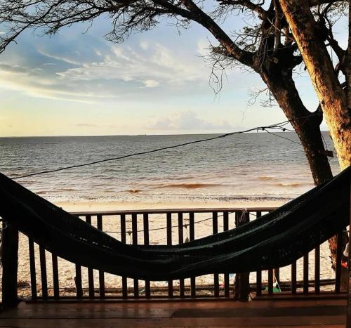 a hammock on a beach with the ocean at CHALÉ ANGELIM in Belém
