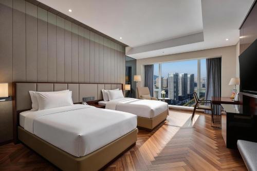 two beds in a hotel room with a view at Crowne Plaza Taizhou by IHG in Taizhou