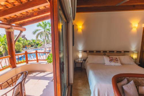a bedroom with a bed and a balcony at Escondite condominios in Zihuatanejo