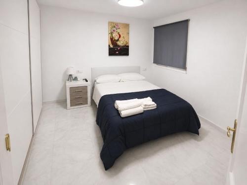a bedroom with a bed with two towels on it at Ático Cassinello Roquetas in Roquetas de Mar