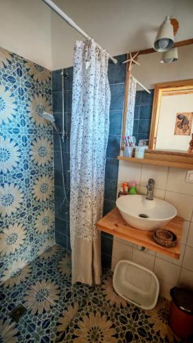 a bathroom with a shower curtain and a sink at BlePelagos house in Glossa