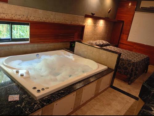 a large bath tub in a room with a bed at Hotel Lido in General Rodríguez